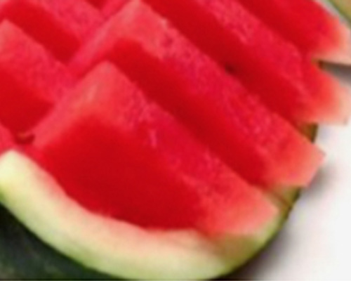 Watermelon slices cut out as triangles on a watermelon shell for easy eating.