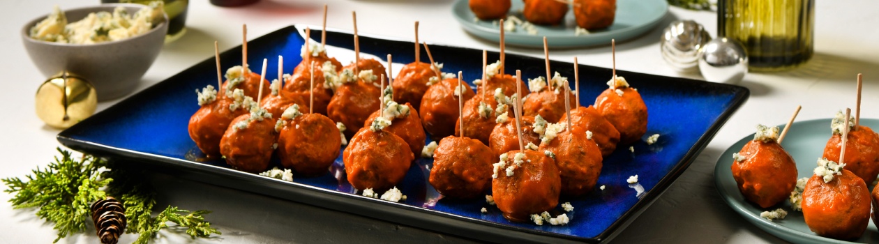 Plate of buffalo chicken meatballs topped with blue cheese