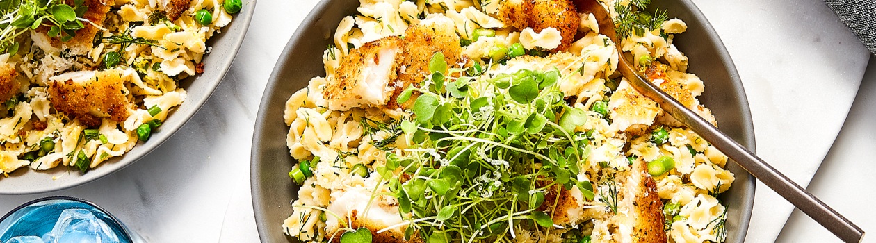 Two large serving bowls of lemon pepper wild sole farfalline pasta with garnish of fresh micro greens