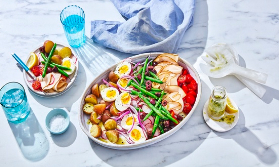 Platter of niÃ§oise salad with beans, hard-boiiled eggs, potatoes, radish, tomatoes, olives and cured meats