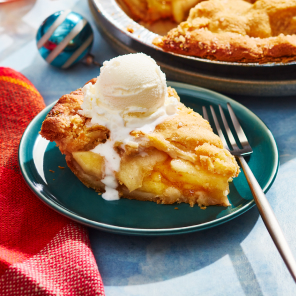 Compliments apple pie with slice taken out and topped with ice cream