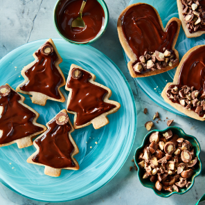 Gingerbread spiced sugar cookies topped with melted chocolate and decorated with pieces of Compliments Gingerbread Flavoured Milk Chocolate Covered Almonds