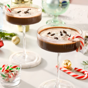 Four glasses of peppermint patty espresso martini with candy cane garnish