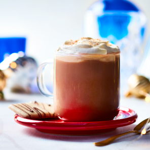 Ro-cocoa in a glass mug on a red plate with some cookies