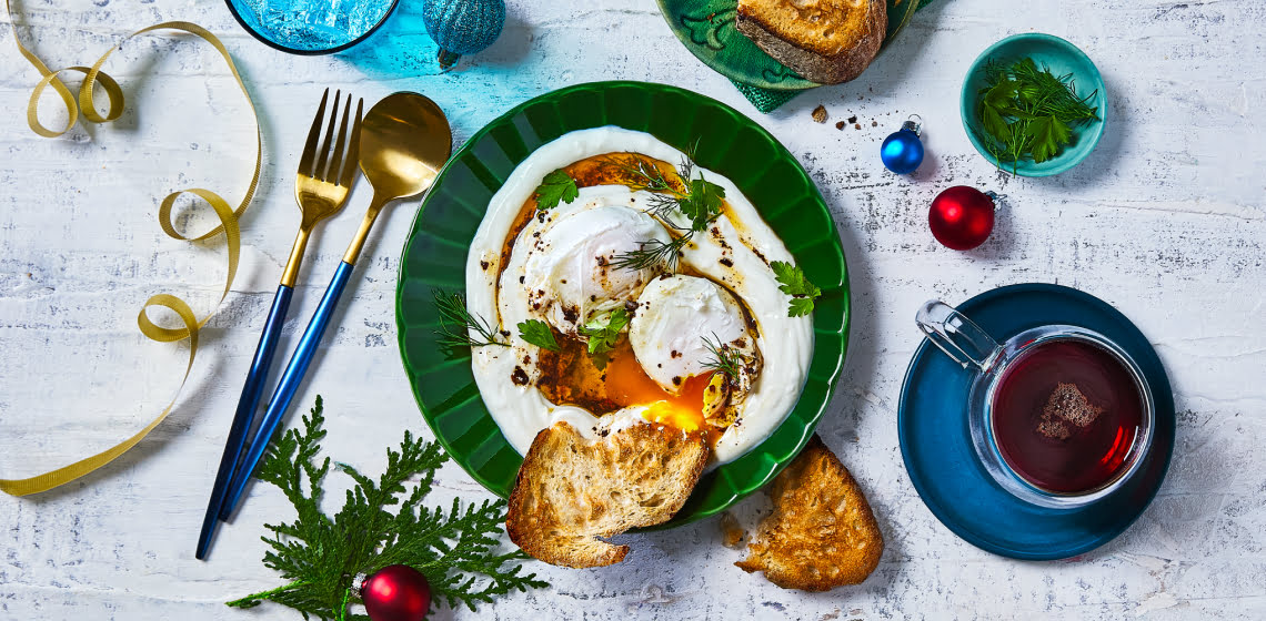 Overhead shot of Turkish eggs with bread on the side