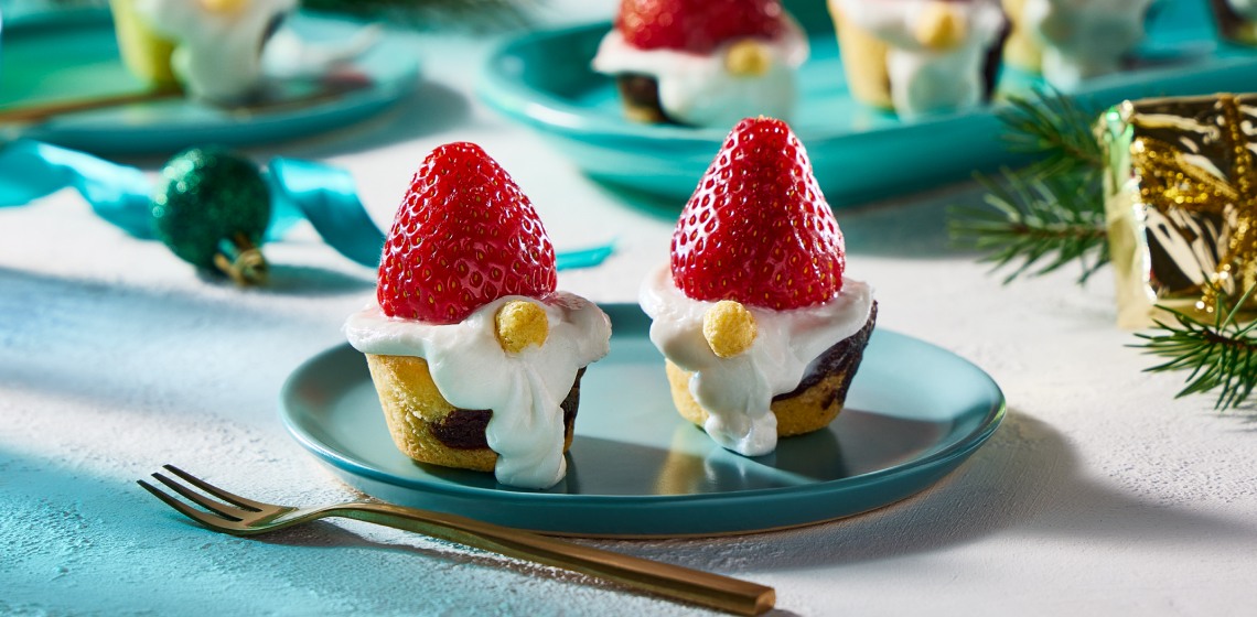 Shot of 2 Christmas gnome brownie bites on a plate with more on a platter behind them