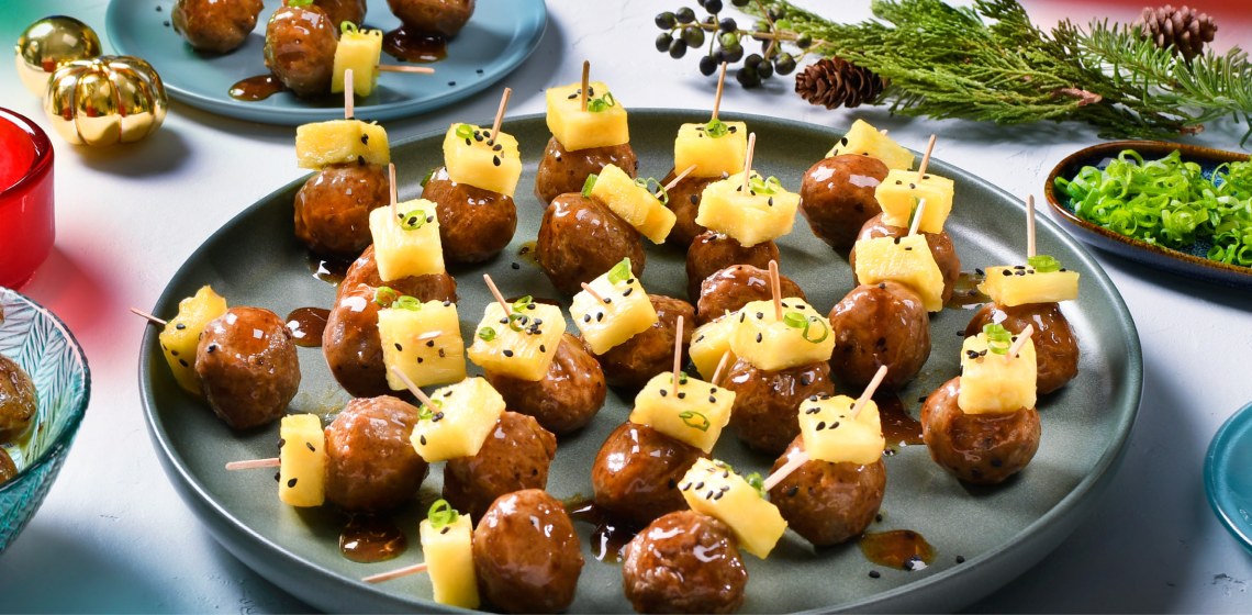 A plate of teriyaki prime rib meatballs with pineapple chunks on top