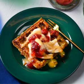 Three holiday dinner waffles, one on a green plate, one on a blue plate and one on a clear green plate