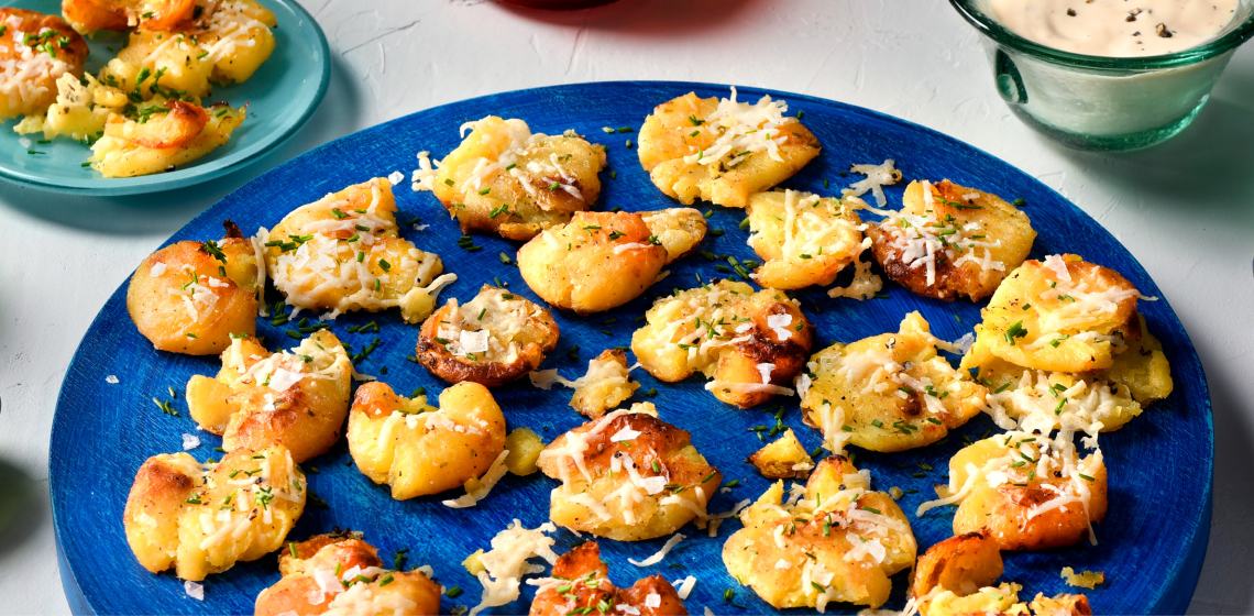 Close-up shot of smashed potatoes on a blue plate