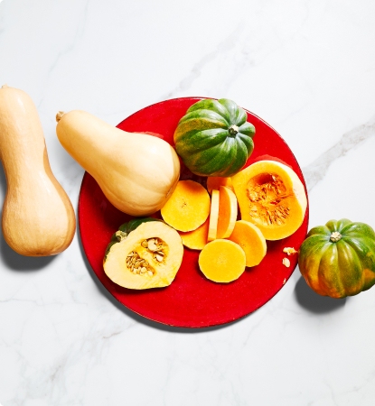 Different varieties of squash on a red plate