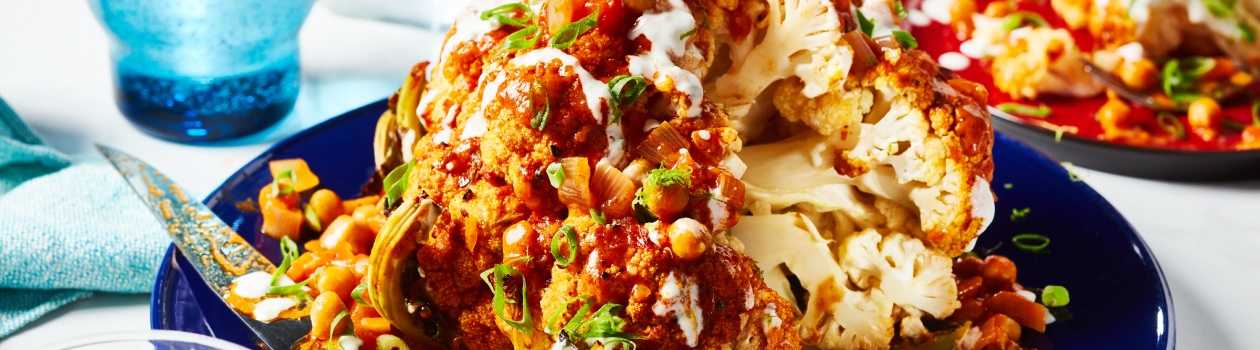 Close-up of whole roasted cauliflower in blue dish