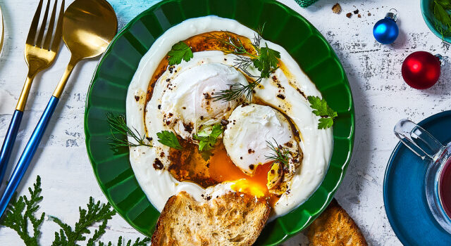 Overhead shot of Turkish eggs with bread on the side