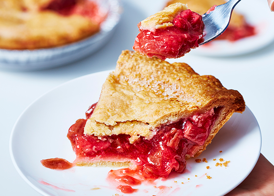 A slice of strawberry rhubarb pie on a white plate.