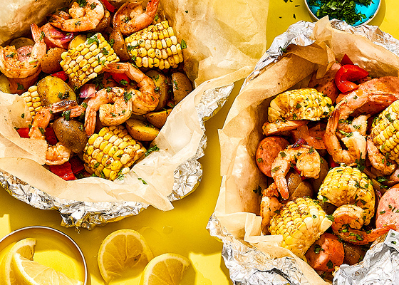 Overhead shot of shrimp boil aluminum packets with shrimp, corn, sausage and potato.