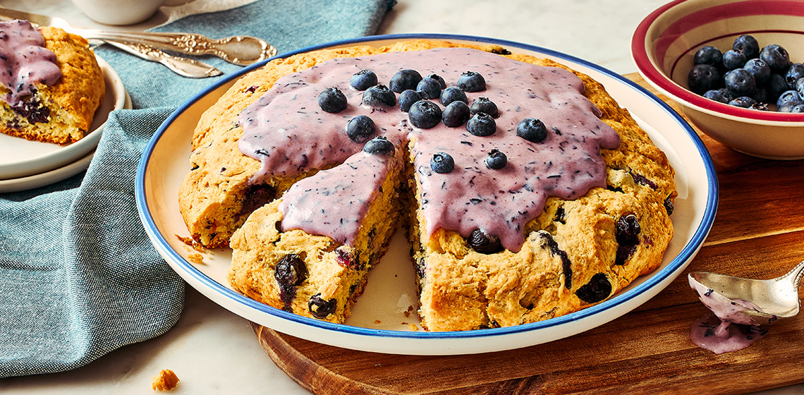 Blueberry bannock with cream cheese icing on a white plate.