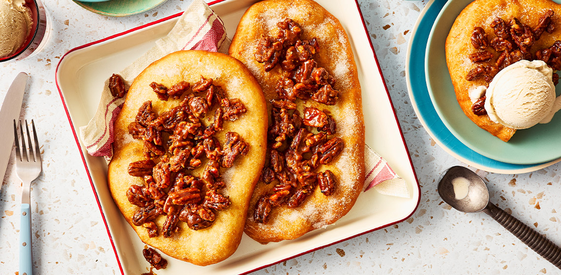 Overhead shot of butter tart fried pastry topped with pecans.