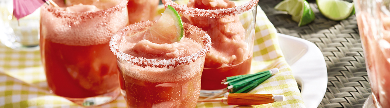 Four glasses of frozen watermelon margarita on a white serving plate.